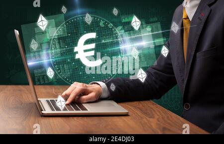 Business Hand arbeiten an der Börse mit Euro-Symbole kommen Aus dem Laptop-Bildschirm Stockfoto