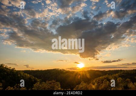 Die Sonne geht unter, während sich dunkle Wolken nähern. Stockfoto