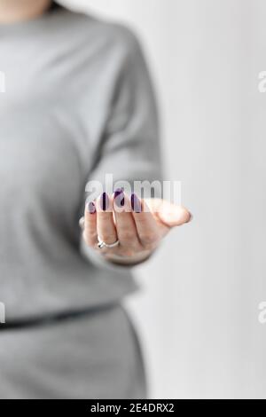 Womans Hände mit langen Nägeln mit violett lila Nagellack Stockfoto