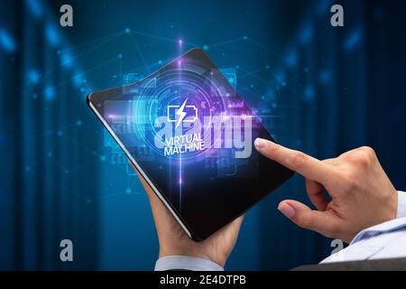 Geschäftsmann Holding ein aufklappbares Smartphone mit HIGH-TECH-Inschrift, neue Technologie Konzept der virtuellen Maschine Stockfoto