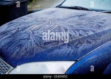 Ein dicker, gemusterter Frost an Windschutzscheibe und Motorhaube eines blauen Ford Mondeo Autos. Stockfoto