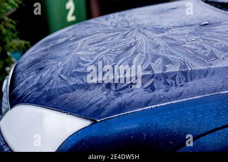 Ein dicker, gemusterter Frost an Windschutzscheibe und Motorhaube eines blauen Ford Mondeo Autos. Stockfoto