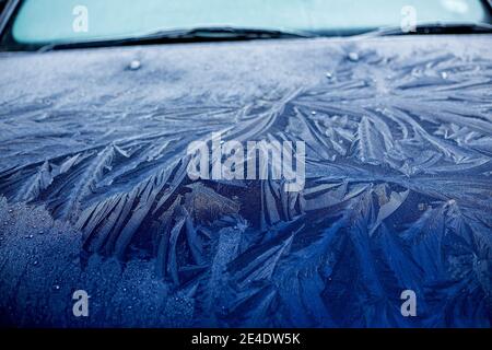 Ein dicker, gemusterter Frost an Windschutzscheibe und Motorhaube eines blauen Ford Mondeo Autos. Stockfoto