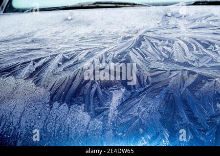 Ein dicker, gemusterter Frost an Windschutzscheibe und Motorhaube eines blauen Ford Mondeo Autos. Stockfoto