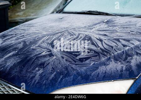 Ein dicker, gemusterter Frost an Windschutzscheibe und Motorhaube eines blauen Ford Mondeo Autos. Stockfoto