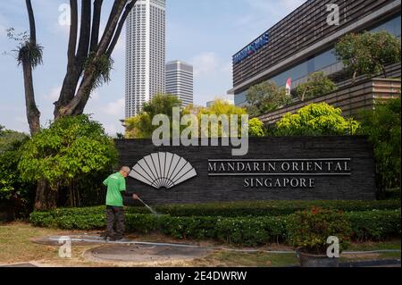 21.01.2021, Singapur, Republik Singapur, Asien – EIN Arbeiter bewässert die Werke im Mandarin Oriental Singapore Hotel, Marina Square. Stockfoto