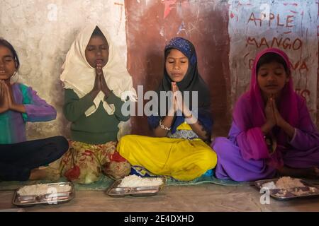 Rajasthan. Indien. 07-02-2018. Kinder beten und essen während der Schule in ihrer Nachbarschaft. Stockfoto