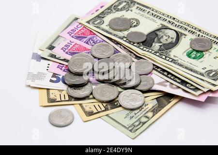 Ukrainisches Geld und amerikanische Dollar auf hellem Hintergrund. Banknoten und Metallmünzen zusammen Stockfoto