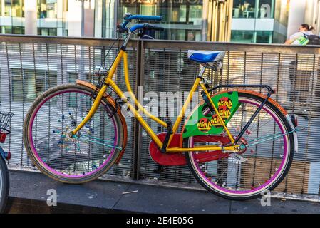 Hannover, Deutschland - 19. August 2019: Altes mehrfarbiges Oldtimer-Fahrrad auf einer Brücke mit Menschen in Hannover, Deutschland geparkt Stockfoto