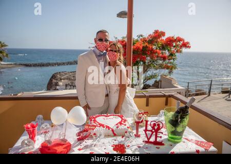 Brautpaare tragen während ihrer Hochzeit Gesichtsmasken, um sich vor Coronaviren zu schützen. Die Hochzeitszeremonie ist neu normal. Stockfoto