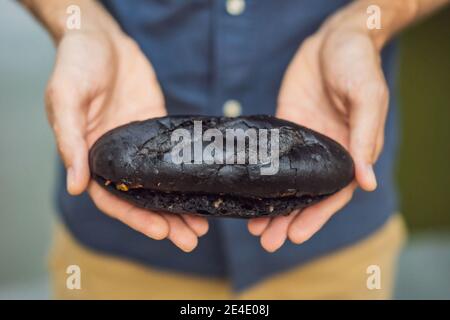 Vietnamesisches Schweinefleisch Banh Mi Sandwich in einem schwarzen Baguette Stockfoto