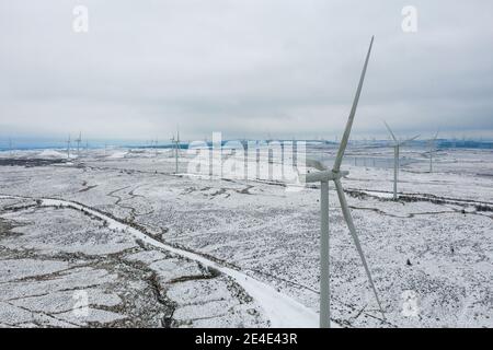 Windpark Whitelee, Eaglesham, Schottland, Großbritannien. 15. Januar 2021. Im Bild: Menschen, die auf der schneebedeckten Moorlandschaft auf der Windfarm Whitelee spazieren und joggen, nehmen ihre tägliche Bewegung an, da Schottland aufgrund der Coronavirus (COVID-19) Pandemie noch in Phase 4 gesperrt ist. Windpark Whitelee unter einem Teppich aus Schnee gesehen, der aufgrund seiner Lage auf dem höheren Boden immer noch auf dem Boden liegt. Es ist beliebt bei Menschen, die ihre Lockdown tägliche Bewegung. Quelle: Colin Fisher Stockfoto