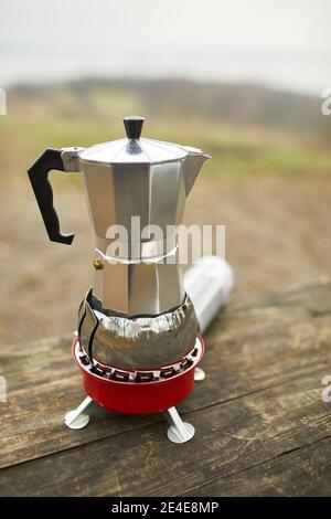 Prozess der Herstellung von Camping-Kaffee im Freien mit Metall Geysir-Kaffeemaschine auf einem Gasbrenner, Schritt für Schritt. Reiseaktivität zum Entspannen, buschboot, Advent Stockfoto