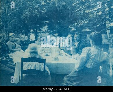 Amerikanisches Archiv Cyanotypisches Porträt eines großen Familienmahls an einem Tisch im Freien. Aufgenommen im späten 19. Jahrhundert in Port Byron, NY, USA Stockfoto