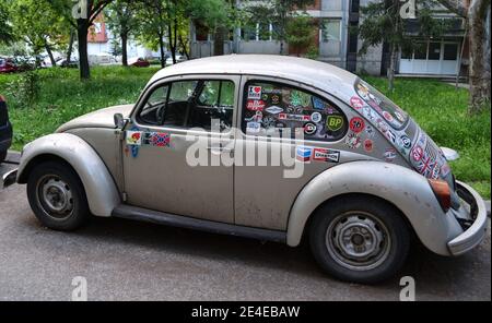 Kultauto und Oldtimer VW Käfer, der auf der ganzen Welt vorbei ist, mit vielen Aufklebern auf ihr, verbringt die letzten Tage verlassen. Stockfoto