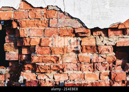 Fragment der alten zerbröckelnden Ziegelwand erschossen Nahaufnahme mit Hintergrundbeleuchtung Stockfoto