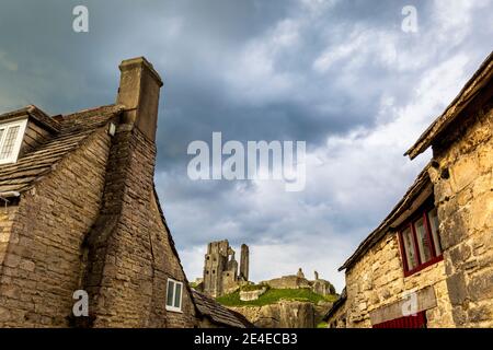 Corfe Castle von zwischen den alten Dorfhäusern, Dorset, England Stockfoto