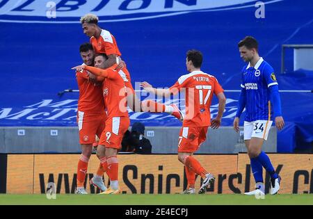 Blackpool's Gary Madine (links) feiert Scoring seiner Mannschaft das erste Tor des Spiels als Brighton und Hove Albion's Joel Veltman (rechts) sieht mit Teamkollegen während des Emirates FA Cup vierten Runde Spiel im Amex, Brighton niedergeschlagen. Bilddatum: Samstag, 23. Januar 2021. Stockfoto