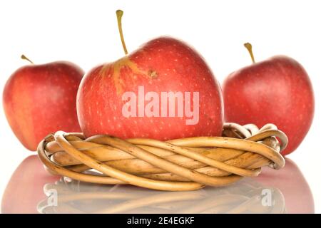 Drei ganze rote leckere reife saftige Äpfel, mit einem Weidenring aus einer Rebe, auf weißem Hintergrund. Stockfoto