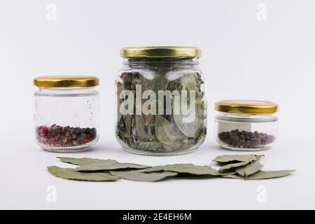 Ein Lorbeerblatt und Pfefferkörner in Glasgefäßen Stockfoto