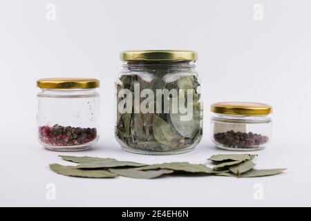 Ein Lorbeerblatt und Pfefferkörner in Glasgefäßen Stockfoto