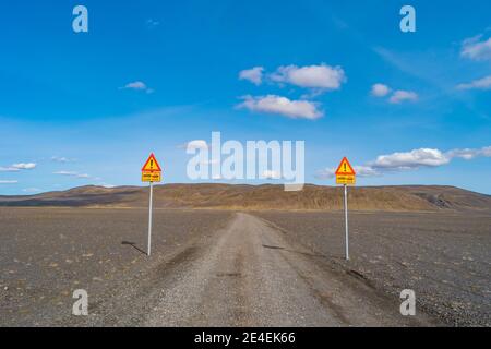 Zwei Schilder, die an der Schotterstraße stehen, warnen vor dem Betreten bewohnbarer Highlands ohne asphaltierte Straßen und der Notwendigkeit, in Island 4WD-Autos zu benutzen Stockfoto