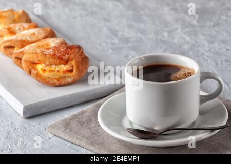 Hausgemachte Kuchen, Tasse Kaffee und hausgemachte Kekse mit Hüttenkäse auf grauem Hintergrund Stockfoto
