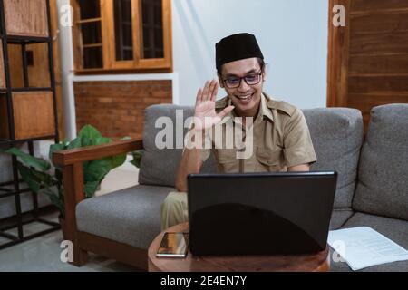 Mann in der Uniform eines Regierungsangestellten, der Online-Meetings mit einem Laptop vorstellt Computer während der Arbeit von zu Hause aus Stockfoto