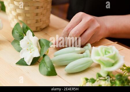 Handgemachte Seife in Form einer Blume in der Hand einer Frau. Stockfoto