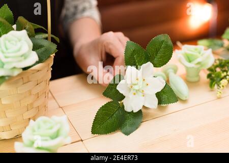 Handgemachte Seife in Form einer Blume in der Hand einer Frau. Stockfoto