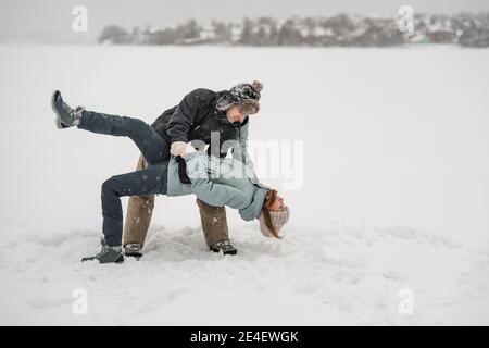 Glückliches Paar tanzt zusammen im Schnee in Winer Stockfoto