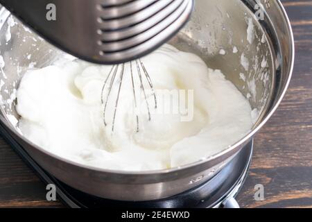 Whisking Egg Whites to make Meringue: Eiweiß, das in einem Standmixer geschlagen wurde, bis sie steife Spitzen bilden Stockfoto