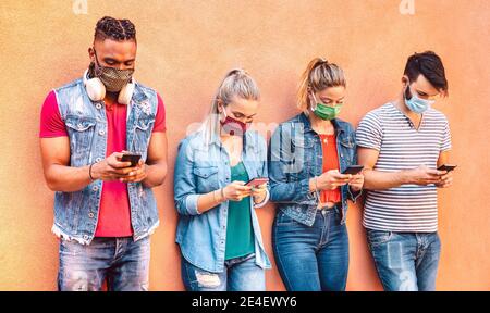 Multirassische Freunde mit geschlossenen Gesichtsmasken mit Tracking-App mit Mobile Smartphones - Junge Menschen, die Inhalte in sozialen Netzwerken teilen Mediennetzwerk Stockfoto