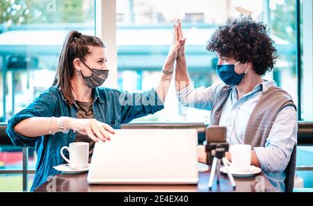 Junge milenial Influencer im Coworking Space mit Facemask - Neu Normales Marketing-Konzept mit der nächsten Generation Paar Spaß haben Stockfoto