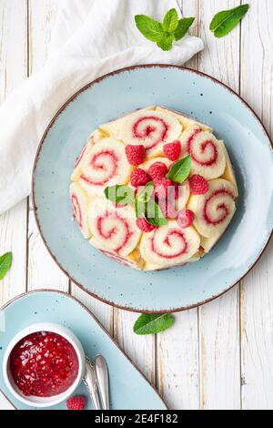 Erfrischender Charlotte royale Kuchen gefüllt mit Himbeermarmelade und dekoriert Mit frischen Beeren auf rustikalem Holztisch Stockfoto