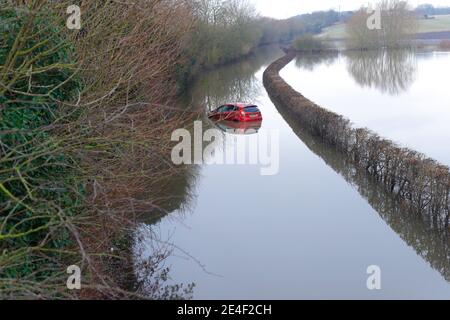 Ein Autofahrer musste sein Auto verlassen, nachdem er während des Sturms Christoph in der Newton Lane in Fairburn im Flutwasser gestrandet war. Stockfoto