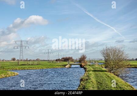 Steinse Tiendweg Wanderweg auf einem schmalen Landstreifen zwischen Kanälen in der Nähe von Gouda, Niederlande unter einem freundlichen Himmel an einem sonnigen Tag im Winter Stockfoto