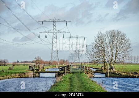 Steinse Tiendweg Wanderweg in den Poldern bei Gouda, Niederlande über die Trajctory von Strommasten und Stromleitungen Stockfoto