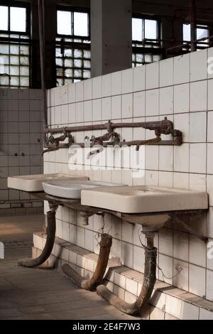 Umkleideraum einer alten Industriefabrik: Waschbecken im Badezimmer und Ankleideraum Stockfoto