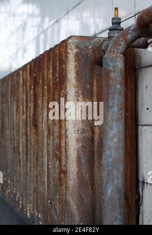 Umkleideraum einer alten Industriefabrik: Alter rostiger Heizkörper Stockfoto