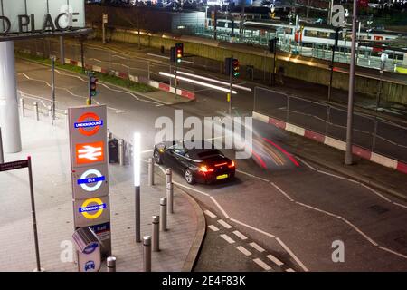 Ein Auto, das hinter einer Ampel vor dem stratford Place Eingang zum Bahnhof und Busbahnhof in London wartet Stockfoto