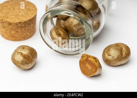 Ein Glas voller Schokoladenpralinen. Süße Trüffel mit Cinamon, Kardamom und Nelke auf weißem, isoliertem Hintergrund. Stockfoto