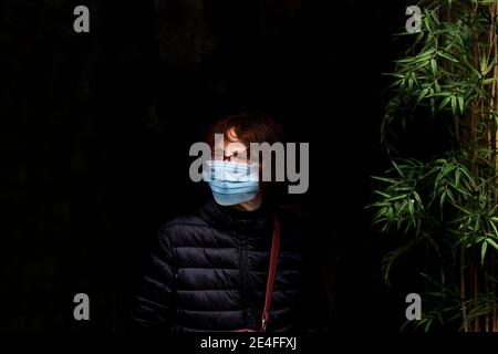 Frau trägt Gesichtsmaske wartet auf den Bus, Barcelona, Spanien. Stockfoto