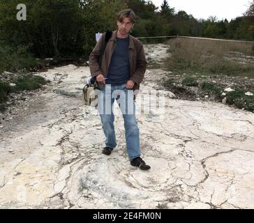 Ein Journalist, der vor der jüngsten Entdeckung eines gut erhaltenen Sauropoden-Dinosaurier-Fußabdrucks zwischen 1.5 und zwei Metern Durchmesser am 6. Oktober 2009 in der Nähe von Plagne, Jura, Ostfrankreich, steht. Die Entdeckung, die im April gemacht wurde und vor 150 Millionen Jahren stammt, wurde von Wissenschaftlern als einzigartige Entdeckung bestätigt. Dies könnten die größten Sauropoden Dinosaurier Spuren jemals in der Welt entdeckt, nach dem National Research French council (CNRS).Foto von Vincent Dargent/ABACAPRESS.COM Stockfoto
