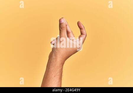 Arm und Hand des kaukasischen Mann über gelb isolierten Hintergrund Schnappfinger für den Erfolg, einfach und klicken Symbol Geste mit der Hand Stockfoto