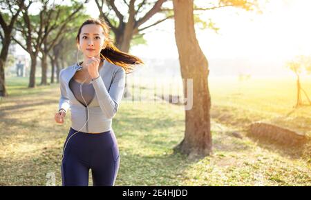 Schöne asiatische junge Frau läuft im Park am Morgen Stockfoto