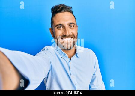 Hübscher Mann mit Bart, der ein Selfie-Foto mit dem Smartphone gemacht hat Schauen positiv und glücklich stehen und lächeln mit einem selbstbewussten Lächeln zeigt Zähne Stockfoto