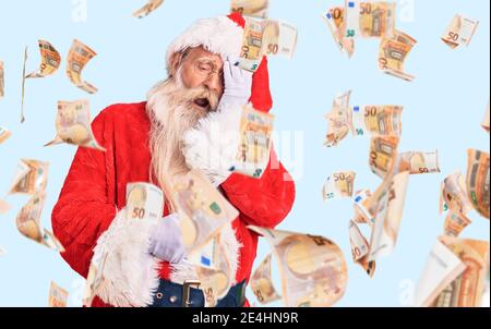 Alter älterer Mann mit grauen Haaren und langem Bart trägt traditionelle weihnachtsmann Kostüm gähnend müde Abdeckung halb Gesicht, Auge und Mund mit Hand. Gesicht h Stockfoto