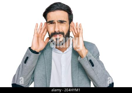 Junge hispanic Mann in Geschäftskleidung versucht, beide Hände auf Ohr Geste hören, neugierig auf Klatsch. Hörproblem, taub Stockfoto