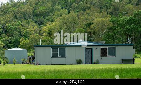 Mackay, Queensland, Australien - Januar 2021: Ein bescheidenes Zuhause auf der Autobahn mit einem Hintergrund von Buschland Stockfoto